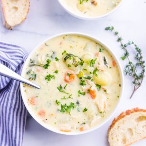 top view of two bowls of gnocchi soup with chicken, spinach, carrots, celery, herbs